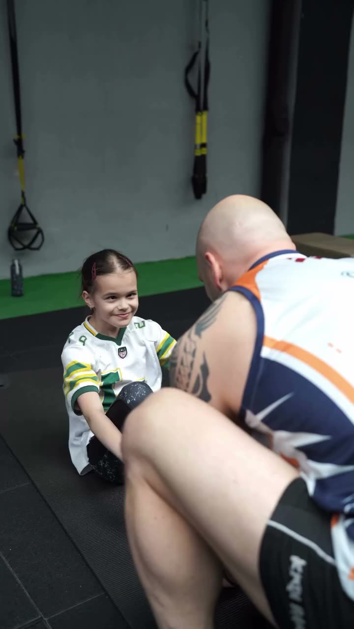 Treneris un meitene bērnu treniņā